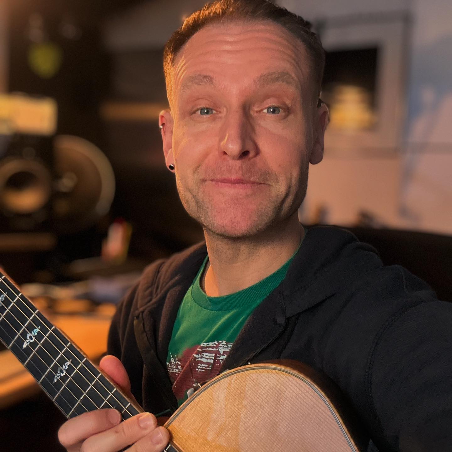 Sebastian Niklaus im Studio mit Gitarre beim Weihnachtslieder üben